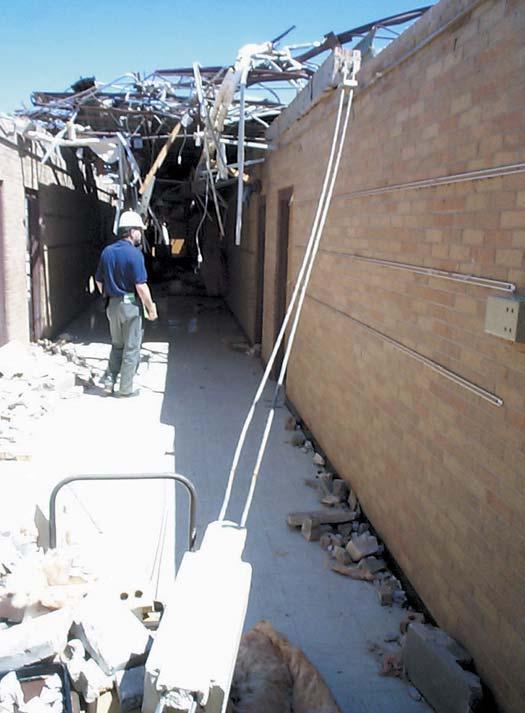 Unreinforced masonry walls failed when the roof system was lifted or removed by tornado winds (Figures 3-17, 3-18, and 3-19).