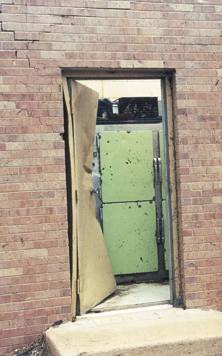 Damage was also caused by the impact of windborne missiles. Figure 3-22 shows a steel door that appeared to have been opened by the impact of a heavy object.