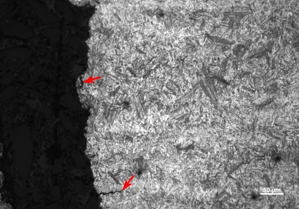 Figure 9 Photomicrograph of untempered martenite in a cracked coupling. Arrows indicate secondary cracks. A less obvious heat treatment error is inadequate austenitization.