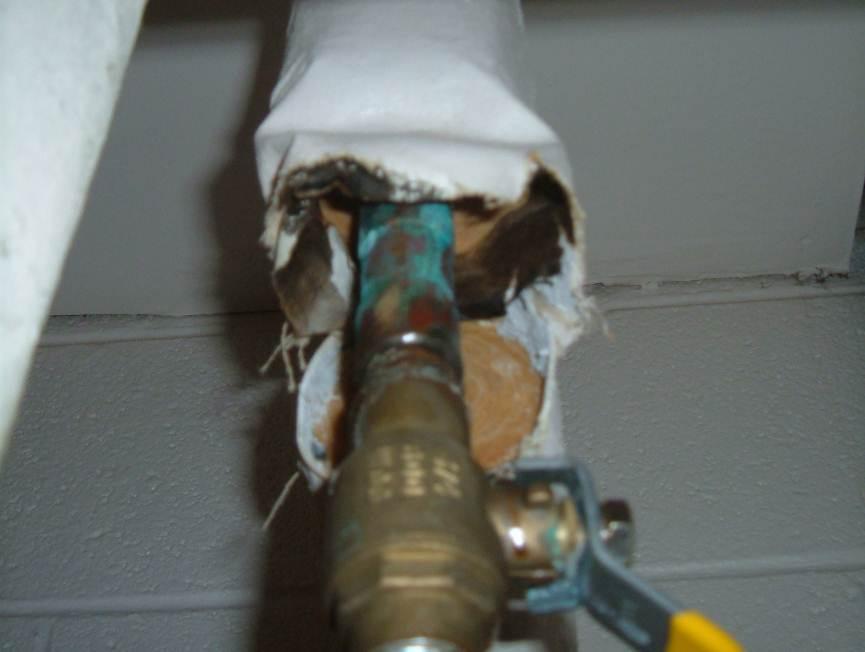 Photograph 1: Pipe fitting insulation debris in the closet of Room CR209, in poor