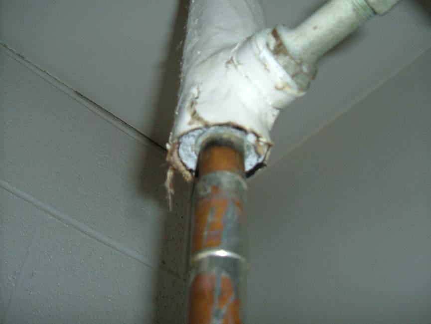 Photograph 2: Pipe fitting insulation debris in the closet of Room CR210, in poor 