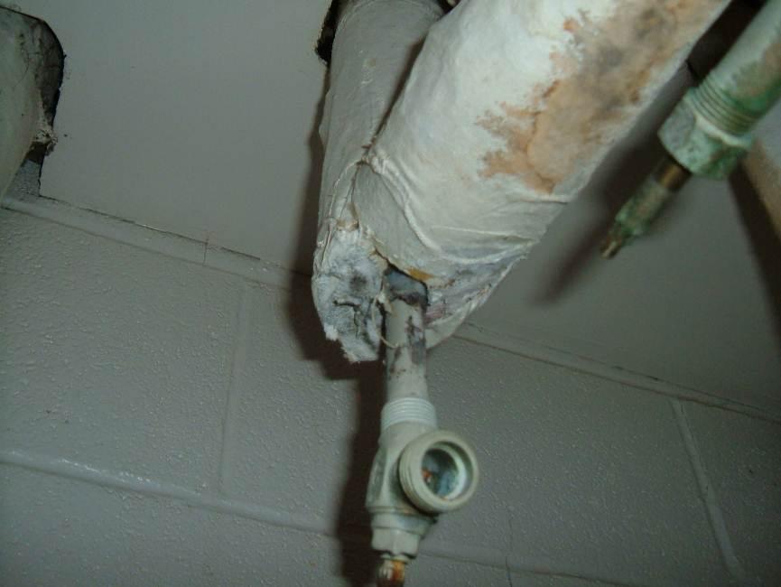 Photograph 3: Pipe fitting insulation debris in the closet of Room CR108, in poor condition.