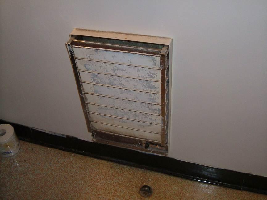 Photograph 16: Sample CR-16. Asbestos containing transite on heaters in washrooms.
