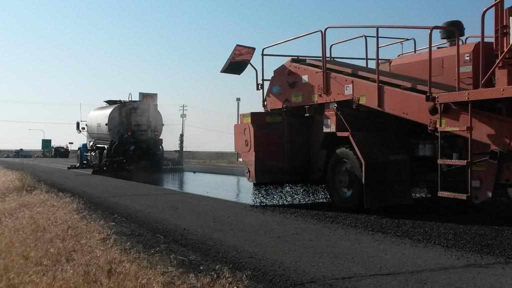 Pre-coated chips are dropped onto the asphalt cement to provide the wearing surface.