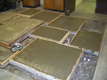 Figure 3-6: Concrete slabs during placement process. slabs wet. After 14 days of moist curing, the burlap and plastic were removed, and the slabs were allowed to cure in open air for another 14 days.