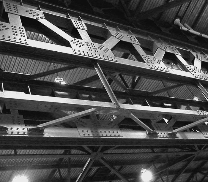 126 hapter 4 Trusses Photo. 4.1: Massive roof trusses with bolted joints and gusset plates. Photo. 4.2: Reconstructed Tacoma Narrows bridge showing trusses used to stiffen the roadway floor system.