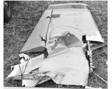 The photograph in Figure 5 was taken of the recovered wing. The photograph of the entire wing is shown in Figure 6, after a resonance caused by the scrape tore it from the fuselage.