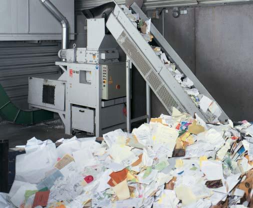 The conveyor belt continuously feeds material to the shredder.