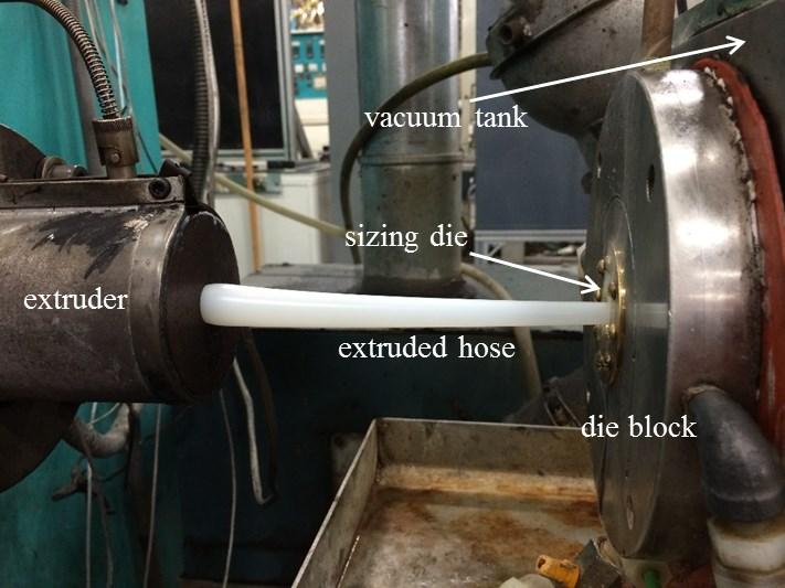 Figure 1: Extruion of a thermoplatic tube on the left and entry into a bra izing die on the right Directly after exiting the vacuum die, the tube enter a vacuum chamber which i filled with water,