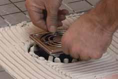ring and snap the grate into mortar and back-butter the underside of the the tile covering and press flush with the tile place.