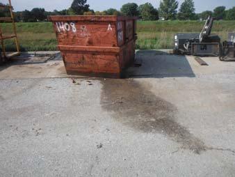Store containers, material, and salvage away from direct traffic routes, drain inlets, catch basins, outfalls, areas prone to flooding or ponding, and floor and trench drains to prevent accidental