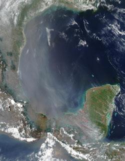 Background NASA/ MODIS are credited for this satellite image of a large haze, smoke plume over the southern Texas, Gulf of Mexico and the Yucatan Peninsula (2).