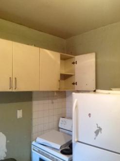 and painted ceilings. Wall-mounted cabinets and a laminated countertop that is complete with a sink are provided.