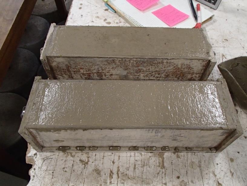 rodding each layer. The specimens were finished to a smooth surface, as shown in Figure 4-21, using a trowel. The molds used to form the specimens were as specified in ASTM C490.