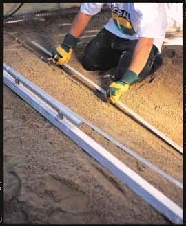 Remove the rails, fill in the voids with bedding Sand and trowel smooth. Set string lines at right angles to establish paving lines.
