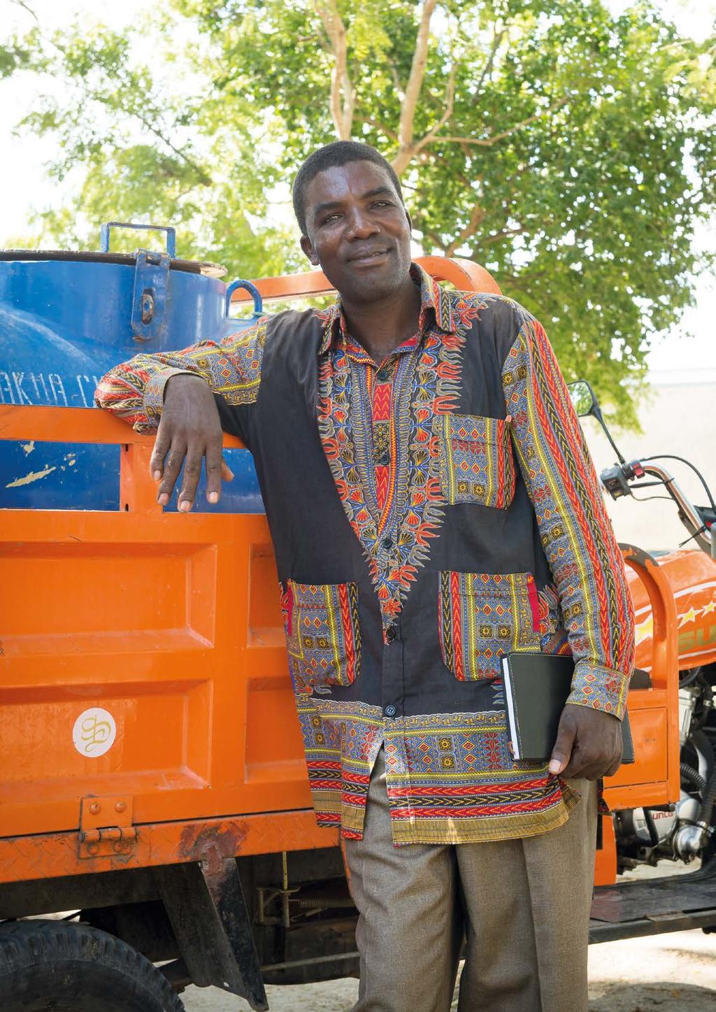 Mattius Millinga, 51, stands next to one of the pajaj vehicles that transports the gulper pump