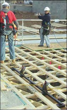 Installing subfloors Workers using a truss