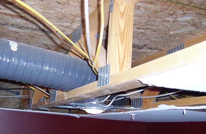 The photograph to the right shows the truss as it was found once the gypsum ceiling was removed. The damaged plate and the resulting deflection can be seen in the lower left corner of the photograph.