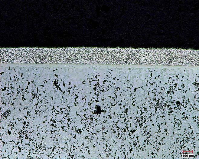 Figure 4. BNi-5- Cr 3 C 2 coating on P/M steel (bottom) with braze/carbide ratio of ~1.2. The pores in the steel adjacent to the coating is partially infiltrated.