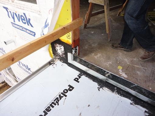 Photograph 6 shows the lapping of the water resistive barrier (WRB) over the vertical portions of the membrane waterproofing. Also note the installation of the balcony door.