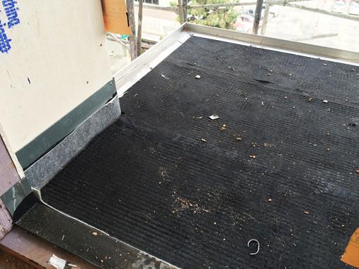 Photograph 8 shows the installation of a drainage mat. The vertical top edge of the perimeter balcony deck waterproofing membrane is yet to be stripped into the exterior wall sheathing with mastic.