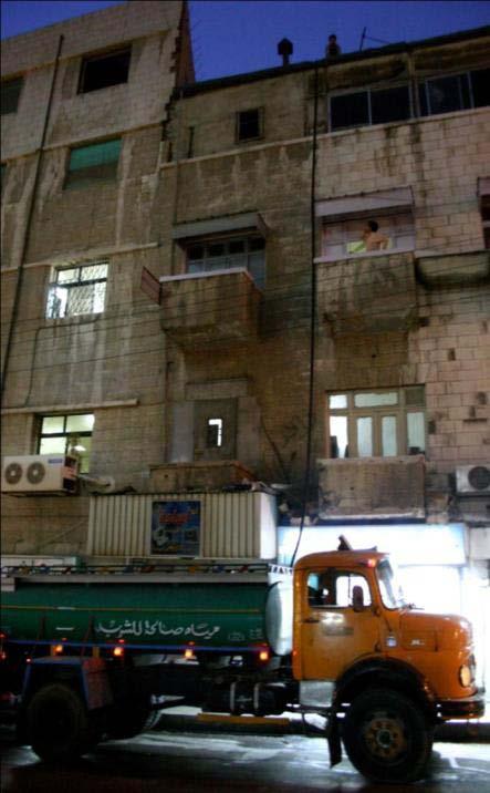 Water truck pumping water up to rooftop tanks downtown Amman, Jordan 17% of the national energy production in J ordan us