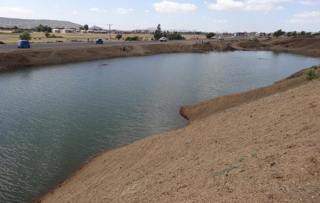 View of a borrow pit used for harvesting water in Axum area, Tigray, Northern Ethiopia. The road embankment is now used as an earth dam and borrow pit as a reservoir.