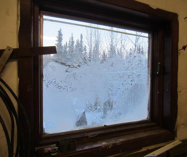 Figure 3: Frost present on mechanical room window and boiler room door. There is a 3 x 6 8 wooden door with an arctic entry on the front (southwestern) side of the building.