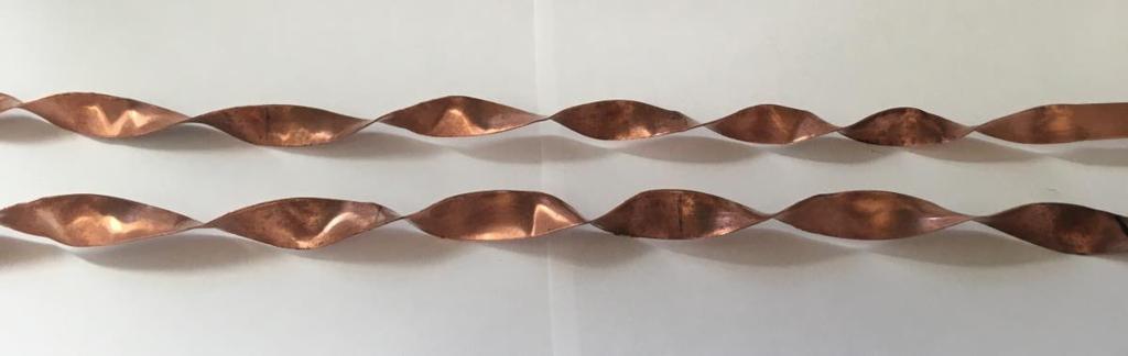 3 and a thickness of 0.8 mm, shown in Fig. 27, were manufactured and inserted into the pipe sections. Fig. 27: Copper twisted-tape inserts with a thickness of 0.8 mm and a twist ratio of 3.