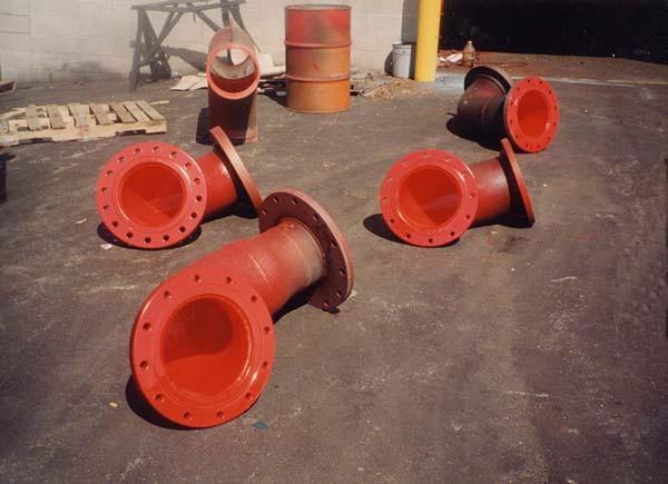 Various large diameter elbows and transition pieces sprayed with