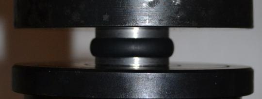 1 The elastomeric specimen bonded to metal plates: the undeformed vs.