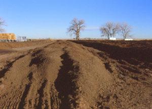 Although you can use a front-end loader, a composting windrow turner is ideal.
