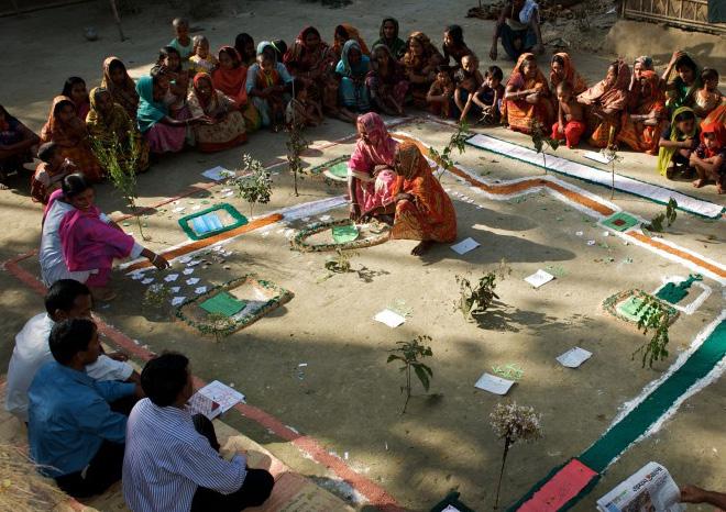A group of men and women attend a Participatory Rural Appraisal