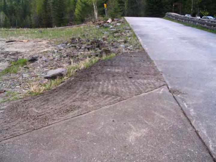 Note exposed geotextile fabric and missing scour protection rock at edge of concrete slab. Photograph No.