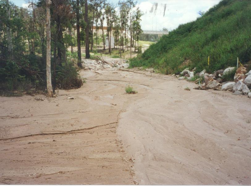 Failure of sediment traps often leads to downslope gully erosion, because the failure usually causes a concentration of flow over surfaces which are not stabilised. See Photo 19 and 20.