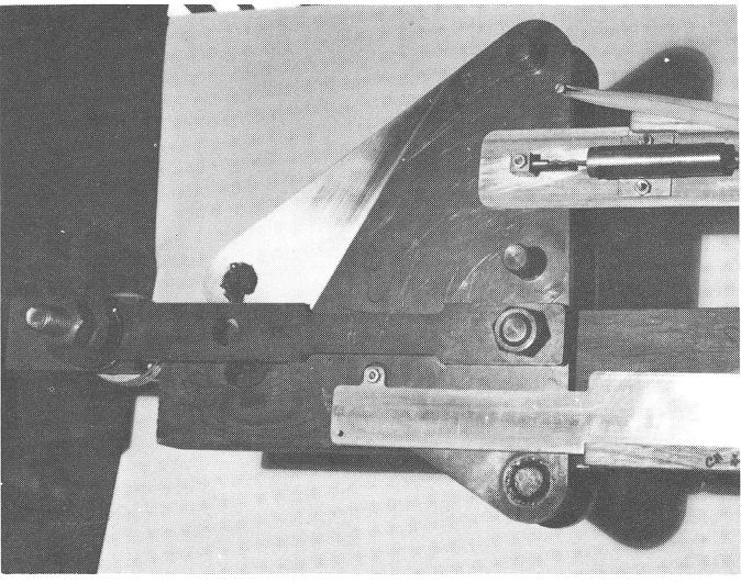 Figure 6. The loading grip setup to apply a low eccentricity load to a test specimen. Note the attachment of the rotation measuring yoke at the rotation reference point (Fig.