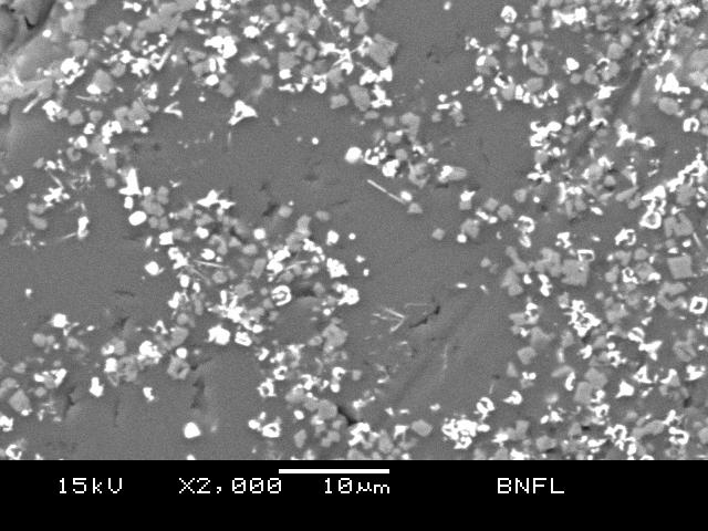 Spinel particles (grey) Glass matrix Zirconium rare-earth particles (white) Figure 2b Spinel particle in a simulated HLW glass at higher magnification, taken on a Jeol JSM-5600 Scanning Electron
