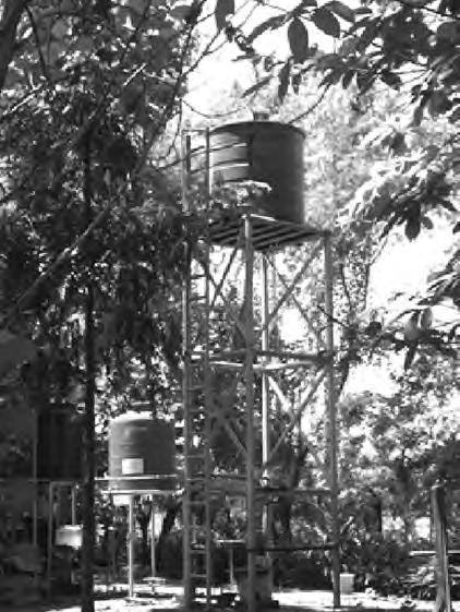 2 1 The photograph below shows a water tower by a house in a tropical country. The water that is stored in the tower is obtained from rain running off roofs of houses.