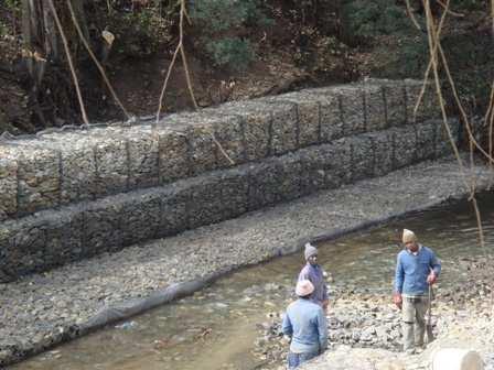 Longitudinal river bank protection Alongside a river embankment parallel to a sensitive installation, walls together