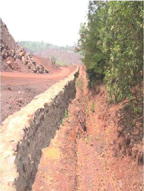 Photo 3 Dumps with Retaining walls and garland drain (xvi) Catch drains and siltation ponds of appropriate size shall be constructed around the tailing pit, mine working, temporary soil, mineral and