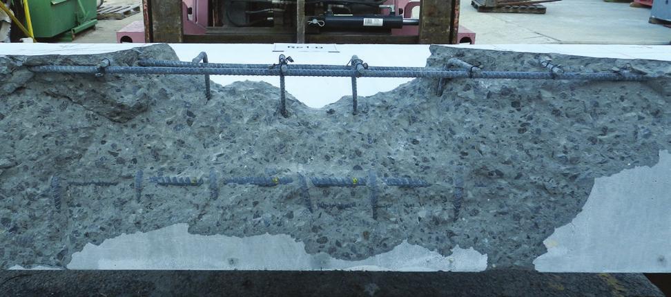 After chipping away the cracked concrete postfailure the bottom view of a typical failure surface revealed that the crack extended into the bottom of the beam and bypassed the hanger bars (Fig. 7).