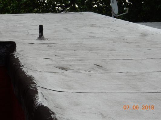 Modified bitumen ( rubber ) roofing, older. Shows some surface crackling which is a sign of age.