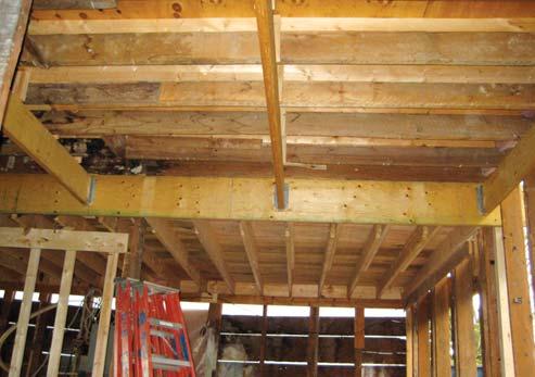 After removing the finishes and exposing the framing, we discovered that a previous builder had shimmed the second-story floor joists to level the floor in the upstairs bedroom over the kitchen area.
