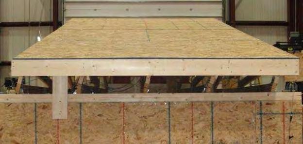 The OSB strip in Specimen E was extended down and nailed to the upper member of the wall double top plate, and as such provided both a rotational restraint for the trusses as well as an additional