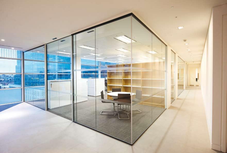 Frameless pivoting glass doors continue the bright and minimalist aesthetic throughout the office.