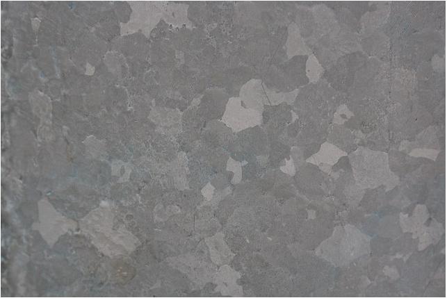 The grains grow from nucleation sites in the melt and prior to drawing they would be randomly shaped grains similar to that seen in the picture of galvanized steel below.