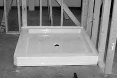 » It will be necessary to rock the shower base until the top of the shower base flange aligns with the lines drawn on the studs.