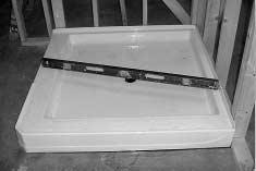 » Insure the base is level in two directions and against the stud framing.» Fit drain assembly into shower base.