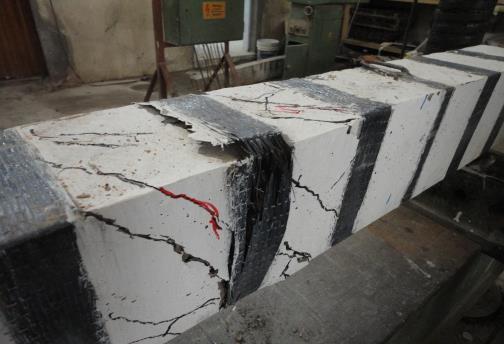 The mode of failure of (S1) was a partial CFRP delamination followed by extensive concrete cracking between CFRP strips which ultimately resulted in beam failure.