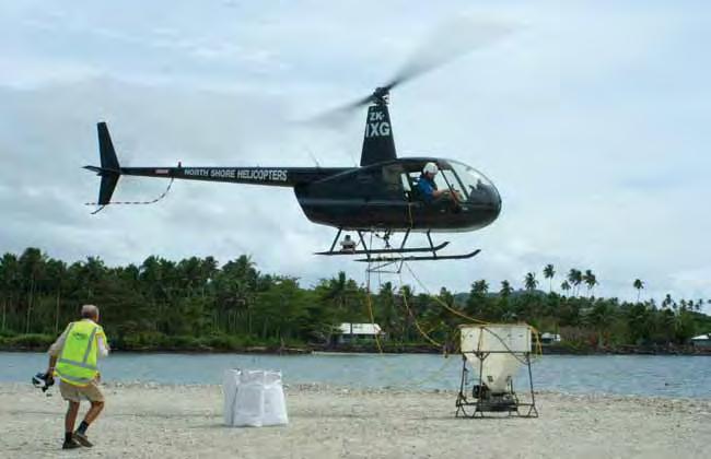 Figure 4. Robinson 44 helicopter, pilot Paul Trapski, with bait spreader bucket ready for loading, all supplied by Northshore Helicopters, New Zealand.